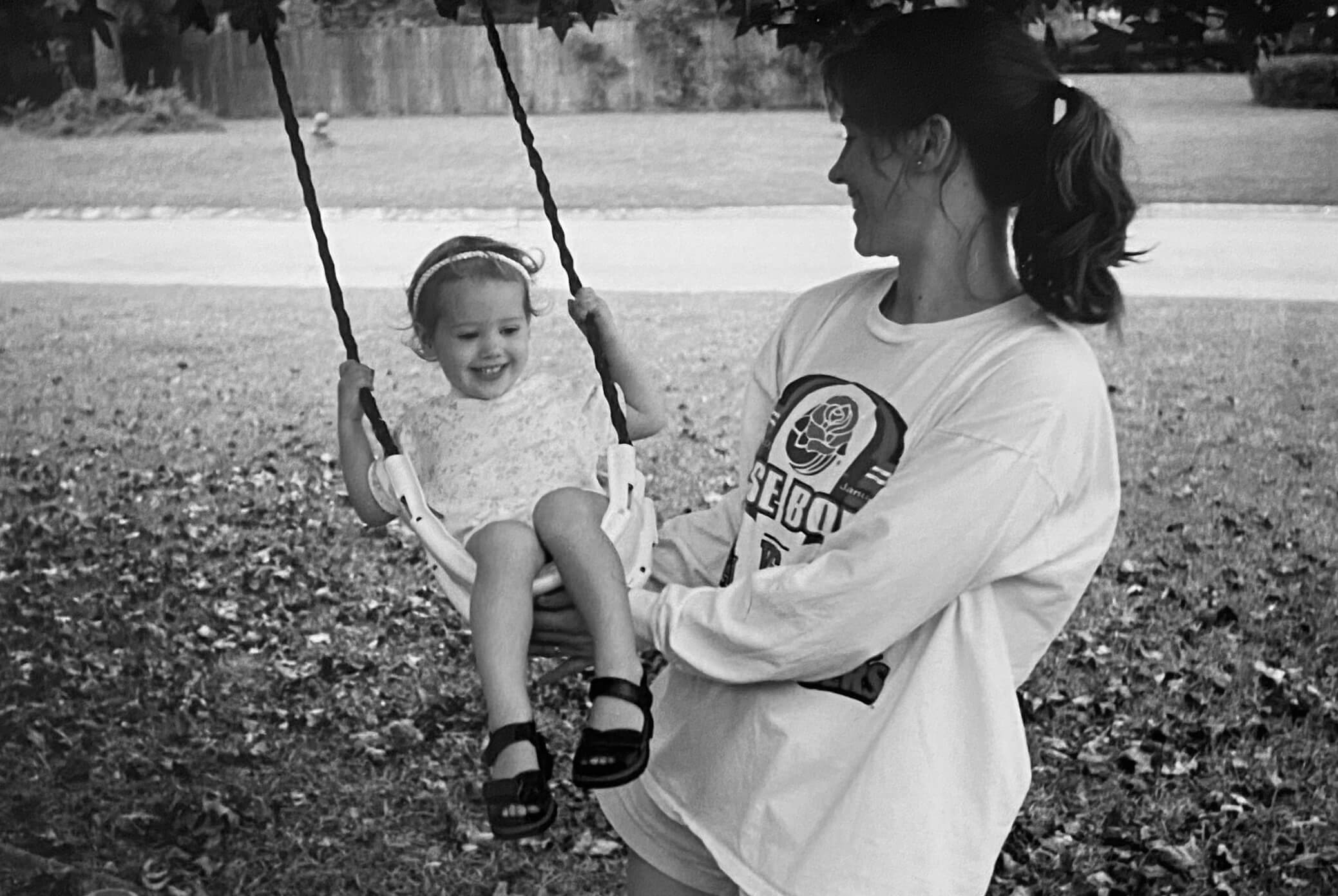 Kendall as a baby being pushed on a swing by her mother